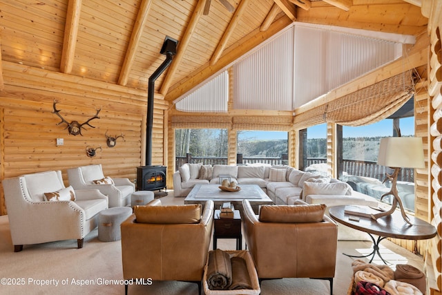 3 Hazel Lake Dr, Cimarron, CO 81220 - carpeted living room featuring a wood stove, high vaulted ceiling, wood ceiling with exposed beams, healthy amount of natural light, and rustic walls