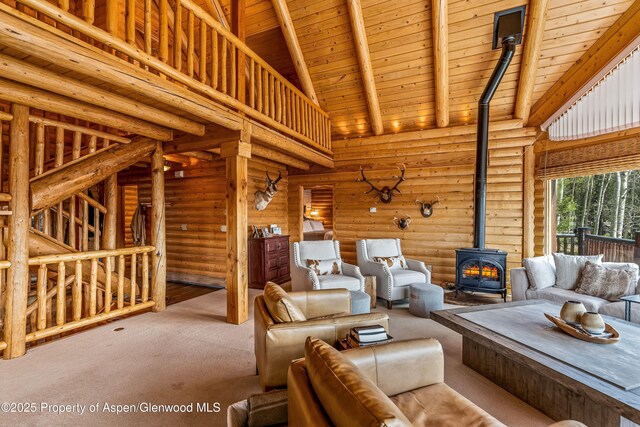 3 Hazel Lake Dr, Cimarron, CO 81220 - living room with a wood stove, wooden ceiling with exposed beams, log walls, carpet flooring, and high vaulted ceiling