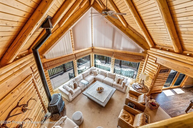 3 Hazel Lake Dr, Cimarron, CO 81220 - living area featuring wood ceiling with exposed beams, a ceiling fan, a wood stove, wood finished floors, and high vaulted ceiling