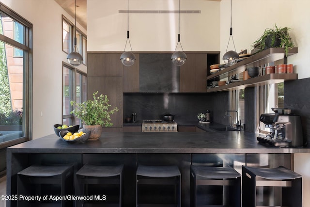62 Bennett Ct, Aspen, CO 81611 - kitchen with open shelves, dark countertops, a kitchen bar, and tasteful backsplash
