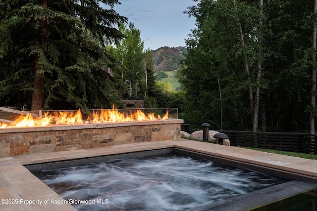 62 Bennett Ct, Aspen, CO 81611 - view of swimming pool with an outdoor hot tub, a mountain view, and a fire pit