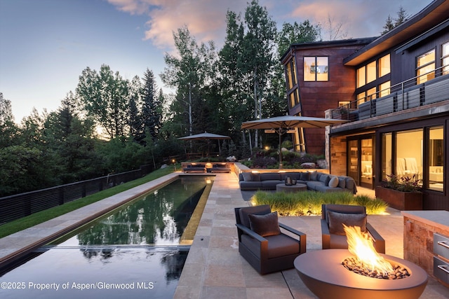 62 Bennett Ct, Aspen, CO 81611 - pool at dusk featuring an outdoor living space with a fire pit and a patio