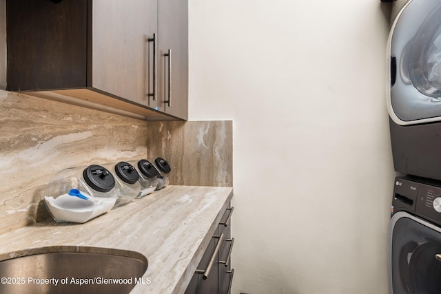 62 Bennett Ct, Aspen, CO 81611 - washroom with stacked washing machine and dryer and cabinet space