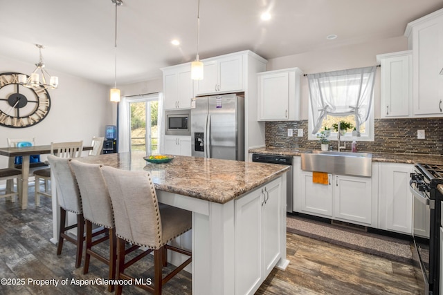 2432 Pioneer Way, Rifle, CO 81650 - kitchen with appliances with stainless steel finishes, a sink, a kitchen island, tasteful backsplash, and dark wood-style floors