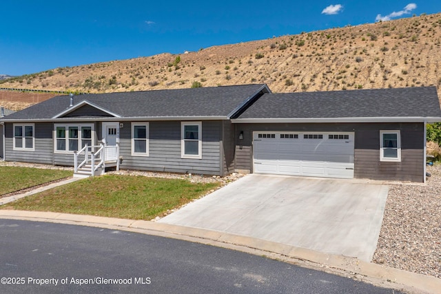 2432 Pioneer Way, Rifle, CO 81650 - single story home with a mountain view, a garage, concrete driveway, and a front lawn