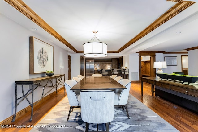 dining space with hardwood / wood-style flooring and ornamental molding