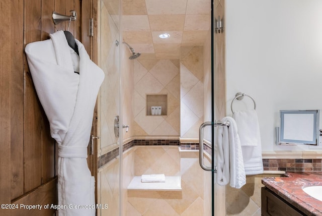 bathroom with vanity and a tile shower