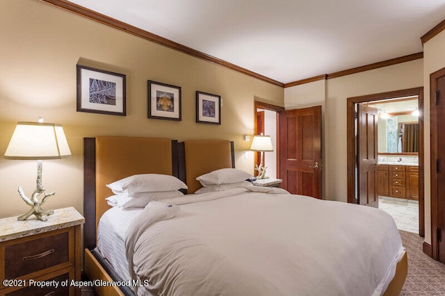 bedroom featuring ornamental molding, carpet floors, and ensuite bath