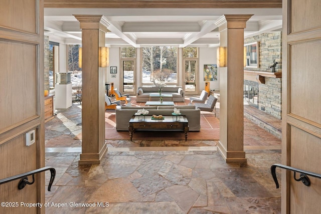 interior space featuring a fireplace, coffered ceiling, beamed ceiling, and ornate columns