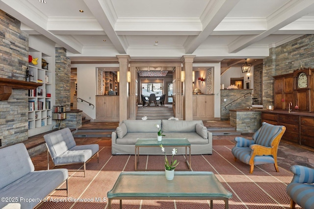 living room featuring beamed ceiling, ornate columns, and stairs