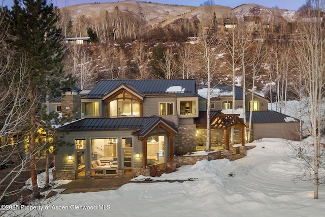 view of front facade featuring metal roof, a standing seam roof, and a mountain view