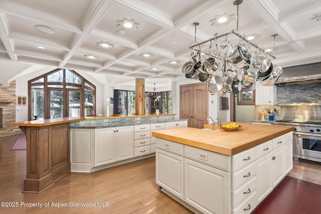 645 Willoughby Way, Aspen, CO 81611 - kitchen with wood counters, a kitchen island, a chandelier, range with two ovens, and coffered ceiling