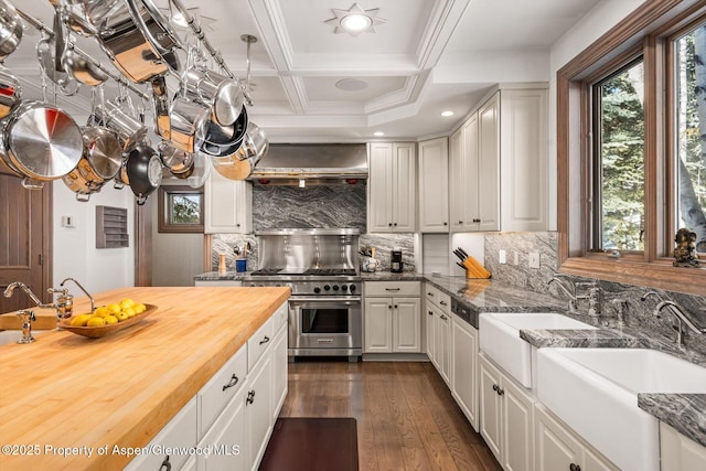 kitchen with butcher block countertops, white cabinetry, wall chimney range hood, stainless steel range, and dark wood finished floors