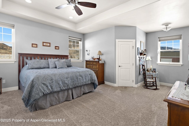 bedroom featuring light carpet, ceiling fan, and multiple windows