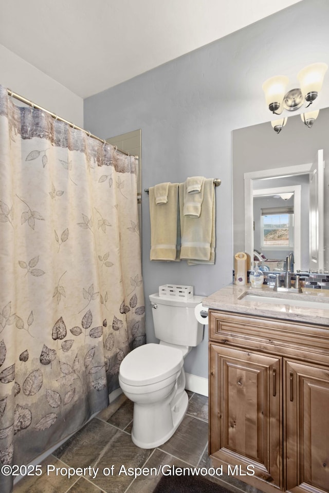 bathroom with toilet, vanity, and a shower with shower curtain