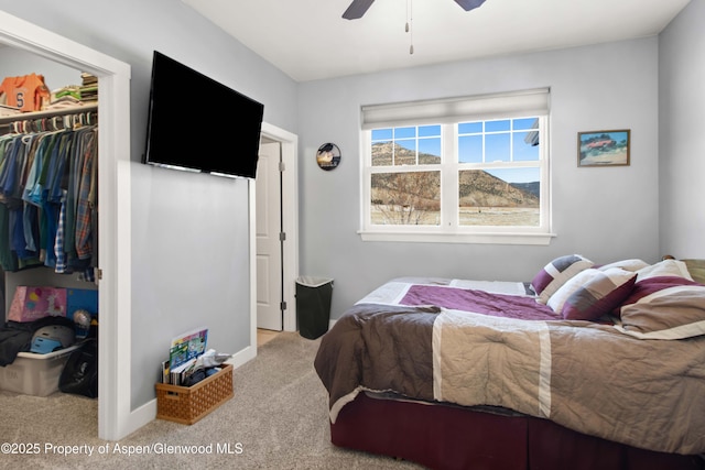 bedroom with ceiling fan, light colored carpet, a spacious closet, and a closet