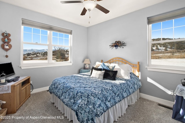 carpeted bedroom with ceiling fan and multiple windows