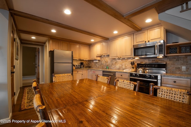 kitchen featuring tasteful backsplash, stainless steel appliances, light stone countertops, beamed ceiling, and sink