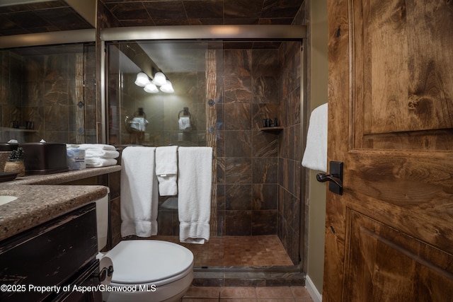 bathroom with tile patterned flooring, toilet, vanity, and walk in shower