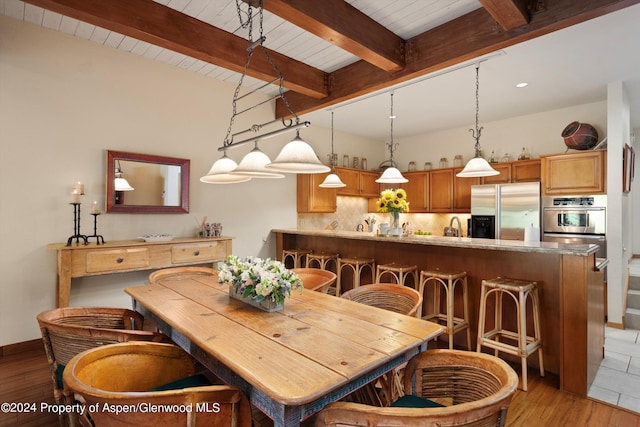 dining space with beam ceiling, light wood-type flooring, and wooden ceiling