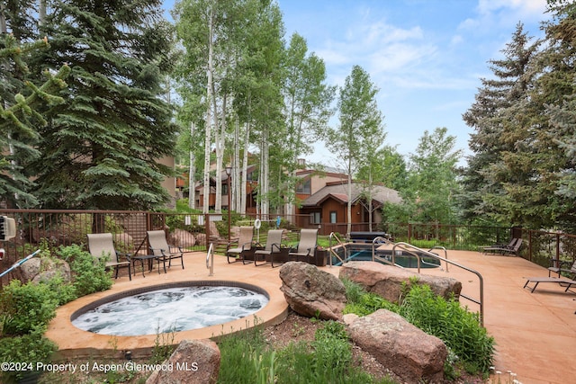 exterior space with a patio area and an in ground hot tub