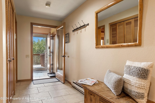 doorway to outside with light tile patterned floors and baseboard heating