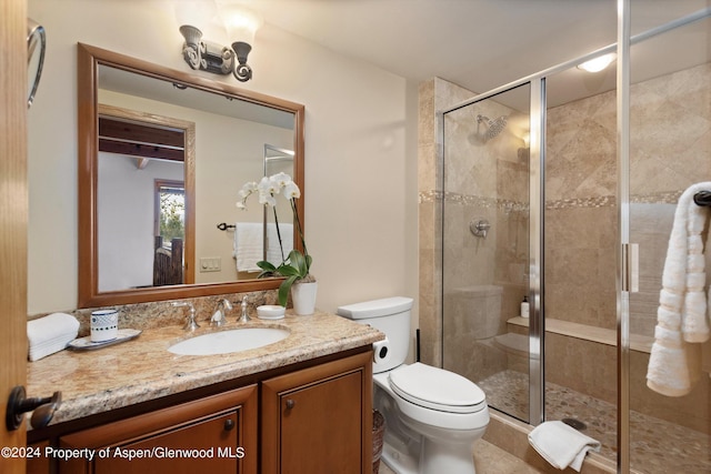 bathroom with vanity, toilet, and an enclosed shower