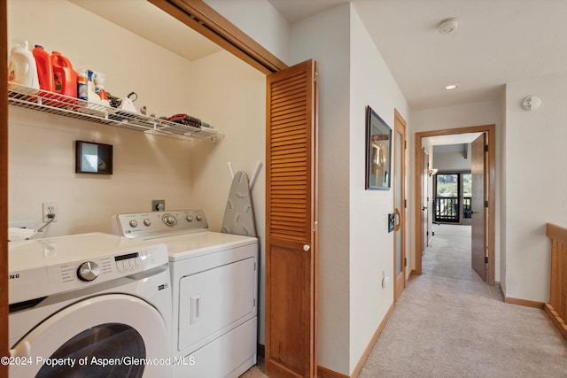 clothes washing area featuring separate washer and dryer and light colored carpet