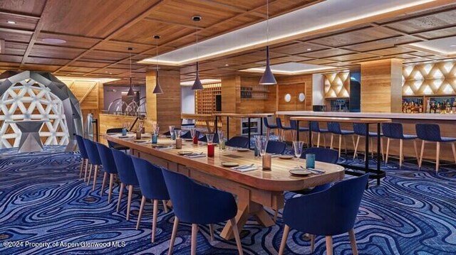 bar with carpet flooring, wooden walls, pendant lighting, and wooden ceiling