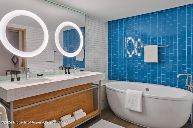 bathroom featuring a tub to relax in, vanity, and tile walls