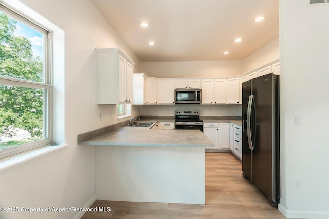94 Castle Ridge Dr, New Castle, CO 81647 - kitchen featuring appliances with stainless steel finishes, a peninsula, white cabinetry, recessed lighting, and light wood finished floors