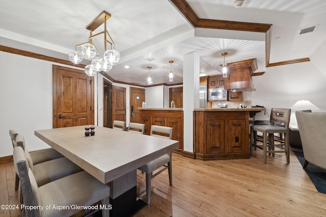 dining area featuring light hardwood / wood-style floors and ornamental molding