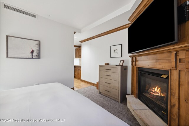 bedroom featuring light wood-type flooring and connected bathroom