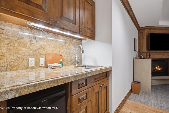 kitchen featuring dishwashing machine, tasteful backsplash, light hardwood / wood-style floors, and sink