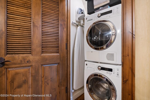 laundry room featuring stacked washer / drying machine