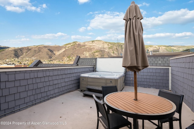 view of patio with a mountain view and a hot tub