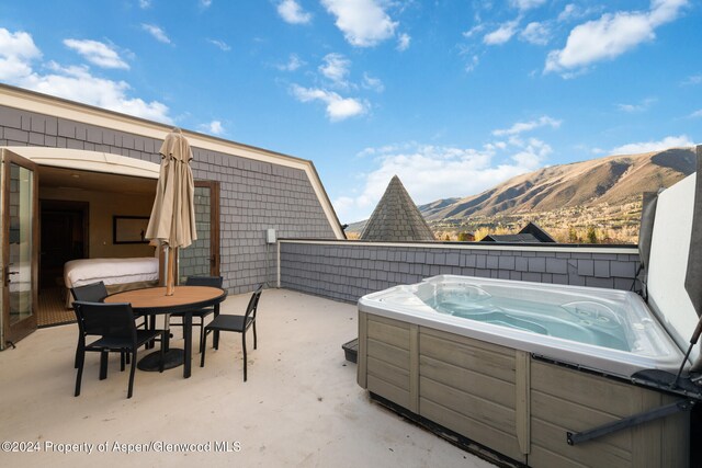 view of patio / terrace featuring a mountain view and a hot tub