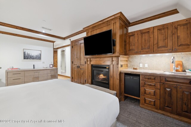 carpeted bedroom with crown molding and sink