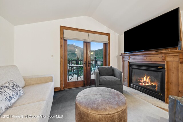 carpeted living room featuring lofted ceiling and french doors