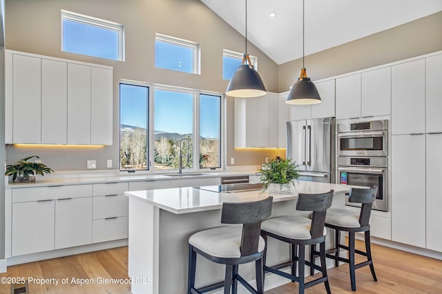 kitchen with modern cabinets, appliances with stainless steel finishes, a breakfast bar, and a sink