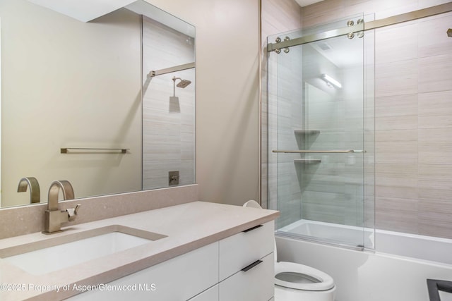 bathroom with shower / bath combination with glass door, vanity, and toilet