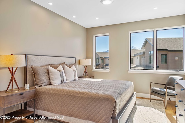 bedroom featuring multiple windows, baseboards, wood finished floors, and recessed lighting