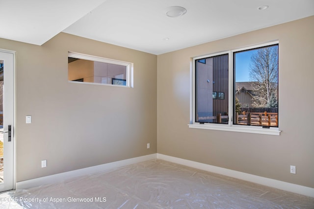 unfurnished room featuring baseboards