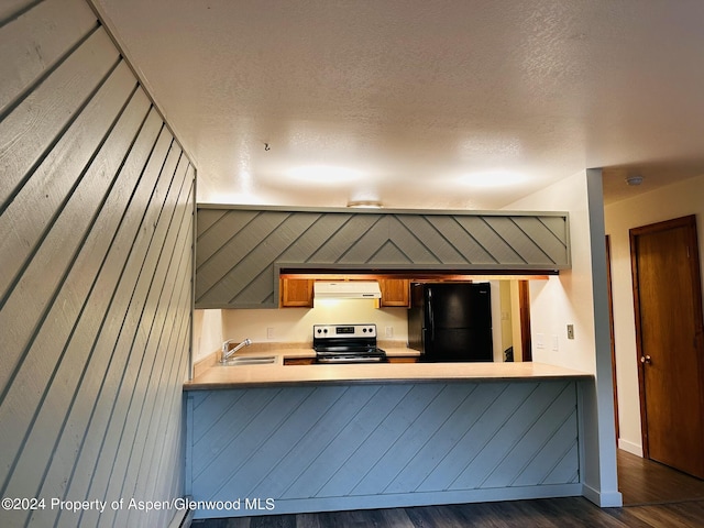 kitchen featuring stainless steel electric range oven, extractor fan, dark hardwood / wood-style floors, black refrigerator, and sink