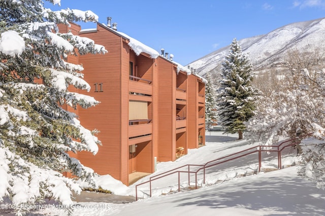 snow covered building featuring a mountain view