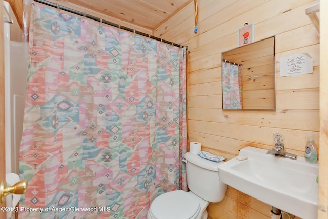 bathroom with wooden walls, sink, wood ceiling, and toilet