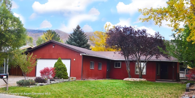 view of front facade featuring a mountain view, a garage, and a front lawn