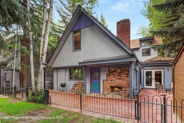 126 W Francis St, Aspen, CO 81611 - view of front facade featuring a fireplace, a fenced front yard, a chimney, and a patio