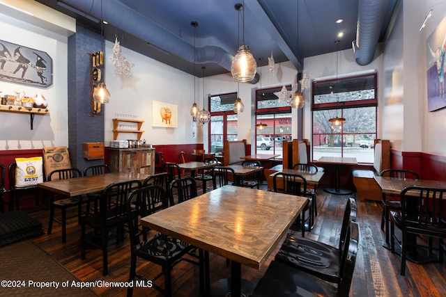 dining space with dark wood-type flooring and a high ceiling