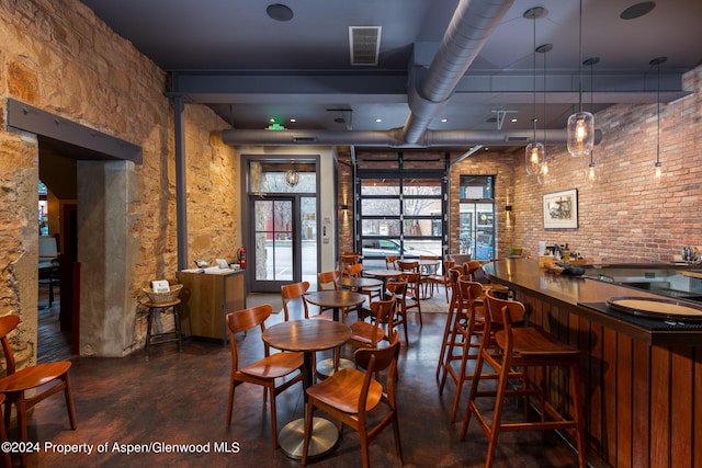 dining area featuring brick wall